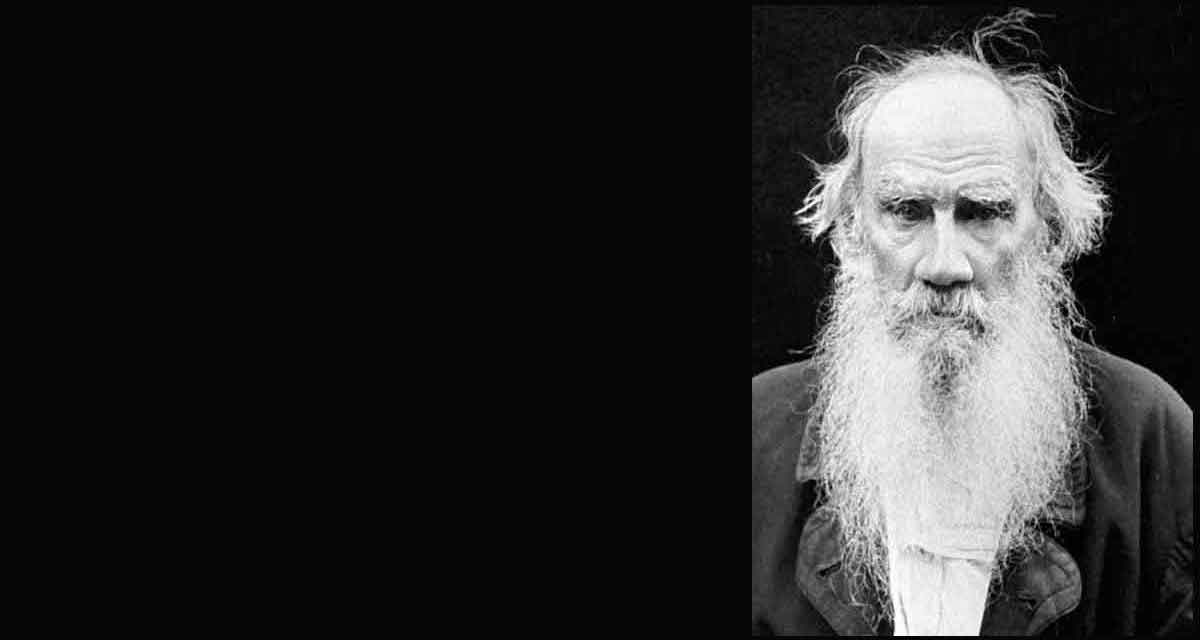 B+W photo of Leo Tolstoy in old age, hairline receded, wild white bearded, a stern expression on his face.